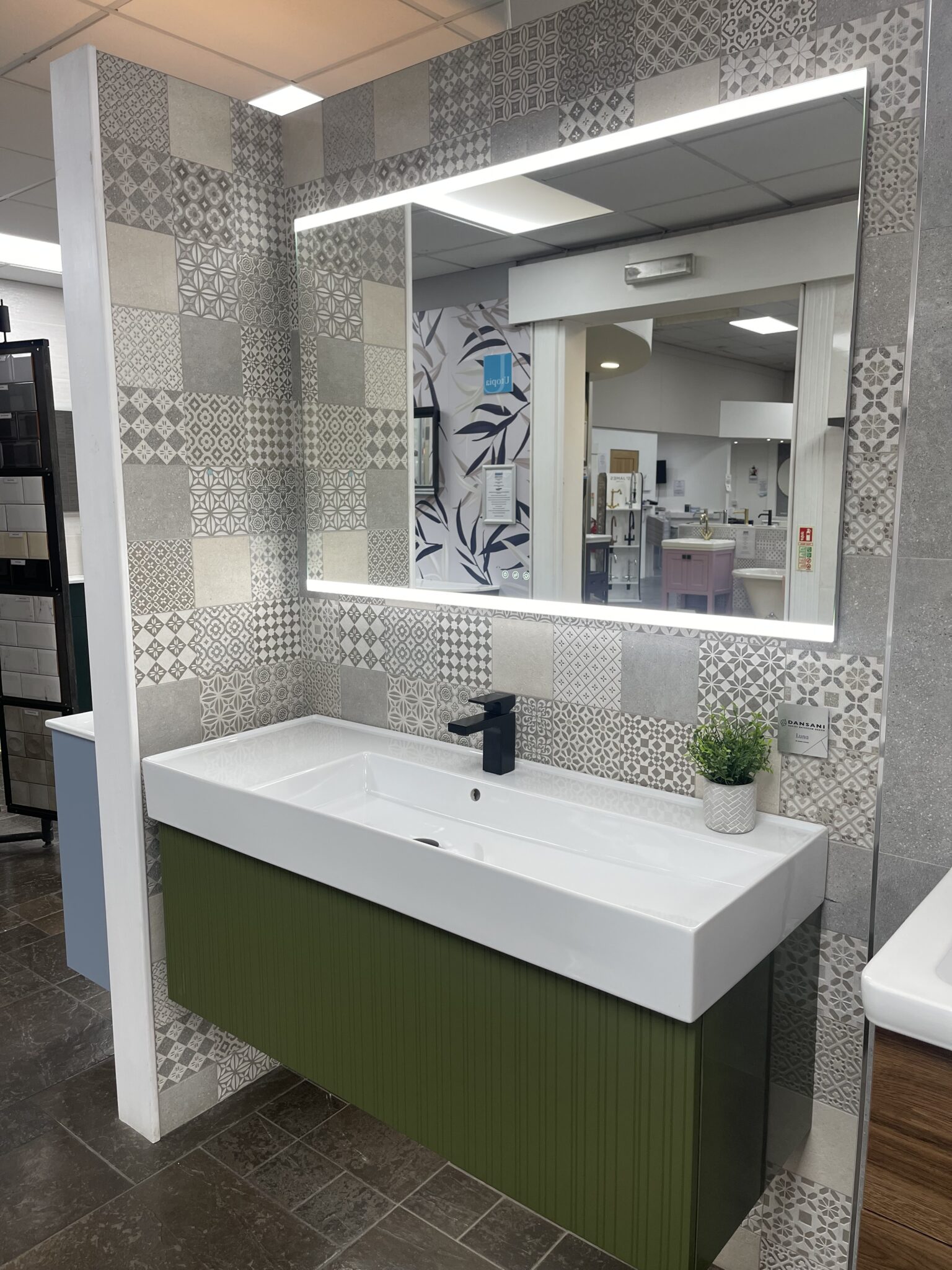 Bathroom display at Coventry Plumbing with LED mirror and green vanity unit